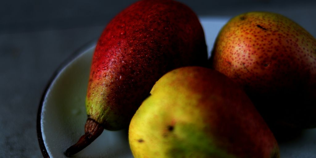 three pears on a plate on a table